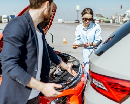 Two drivers inspecting car damage after the traffic accident on the city road